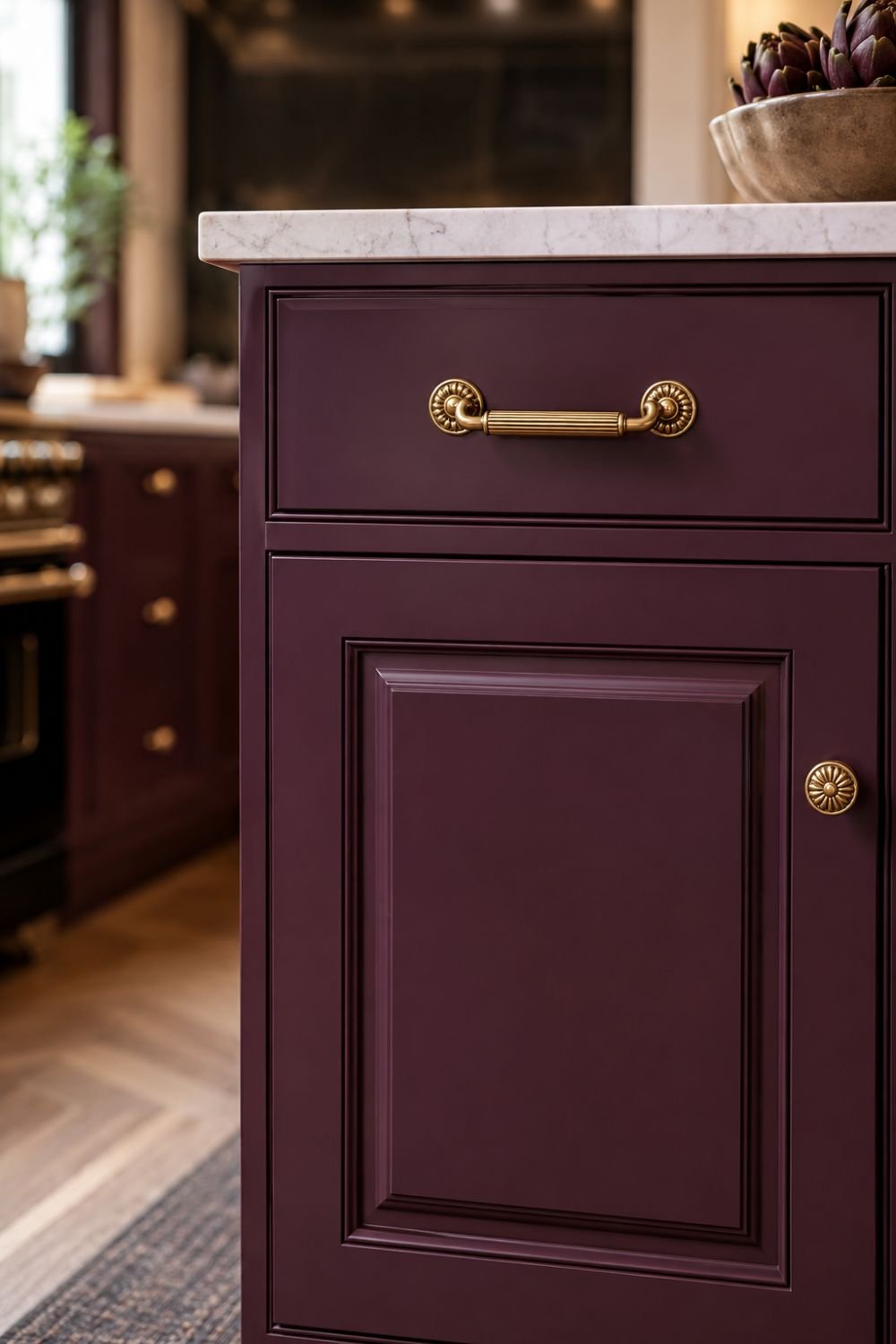 Aubergine cabinets with traditional ornate brass hardware.