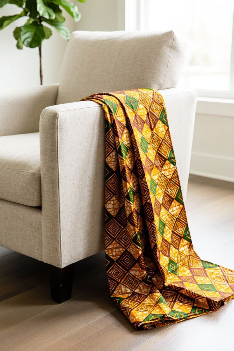 Bold ankara fabric draped over the arm of a natural linen chair in an African boho living room