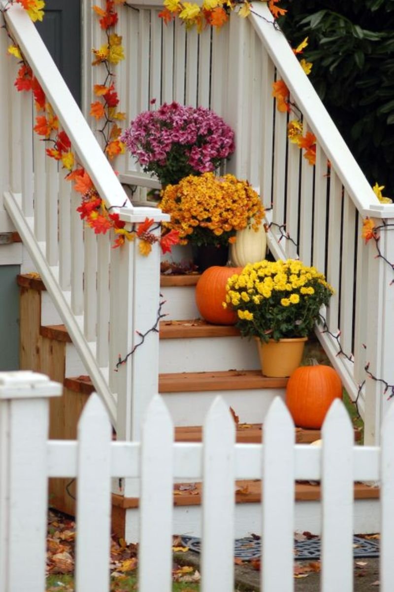 Chrysanthemums terracotta pots flanking front door fall porch decor