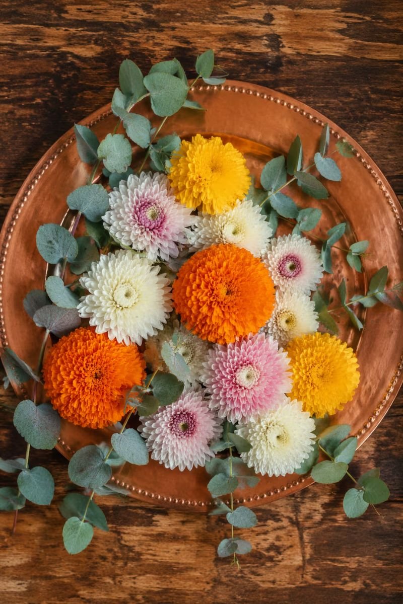 Copper rust harvest Thanksgiving table marigolds chrysanthemums eucalyptus charger plates