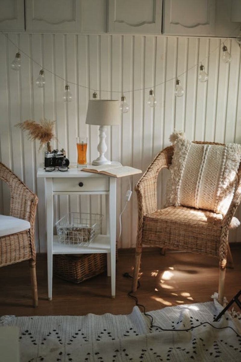 Cozy coastal reading nook with wicker chair and side table on a porch 