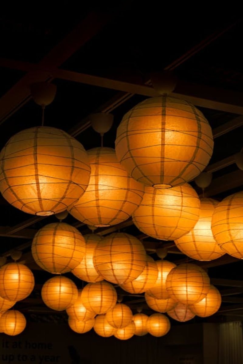 Decorative coastal lanterns with glowing candles arranged on a summer porch