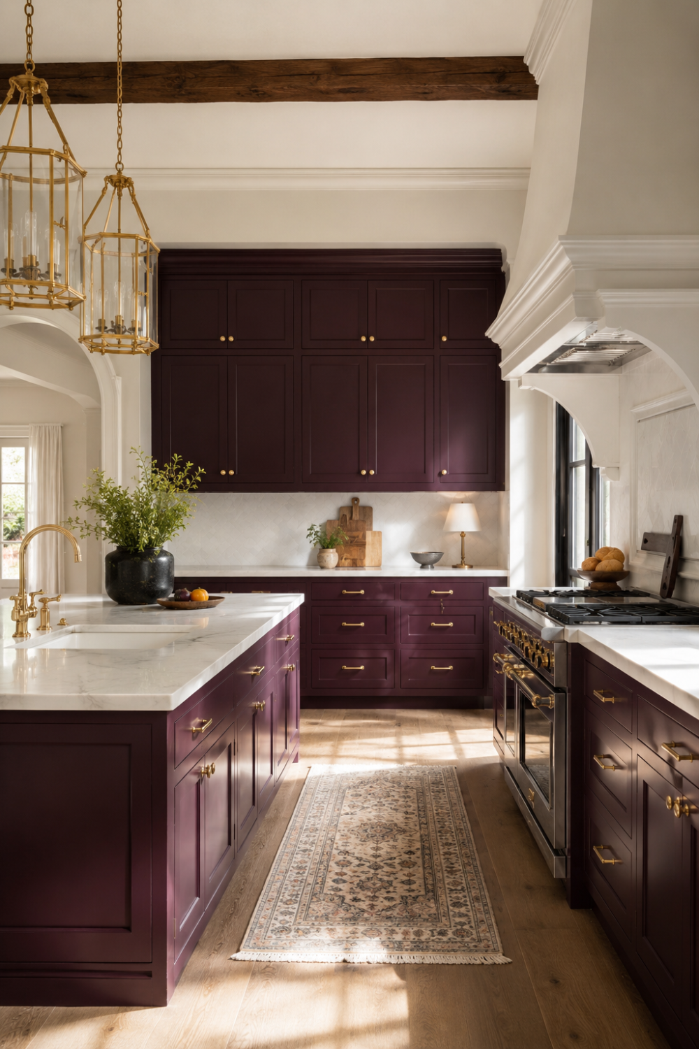 Deep aubergine kitchen cabinets with gold hardware against cream walls