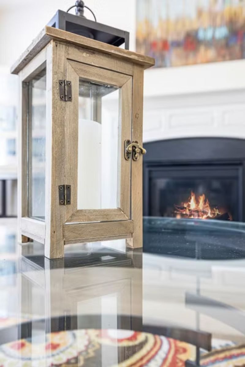 Glass lantern with white candle in a stylish summer living room