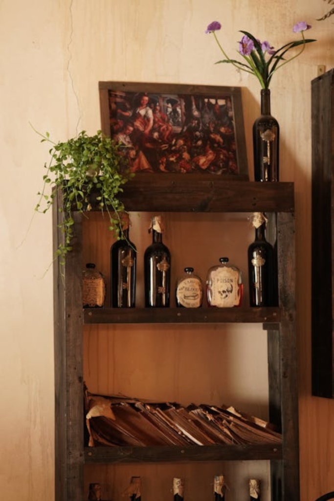 Halloween witch apothecary shelf decor with glass bottles, dried herbs, and candles