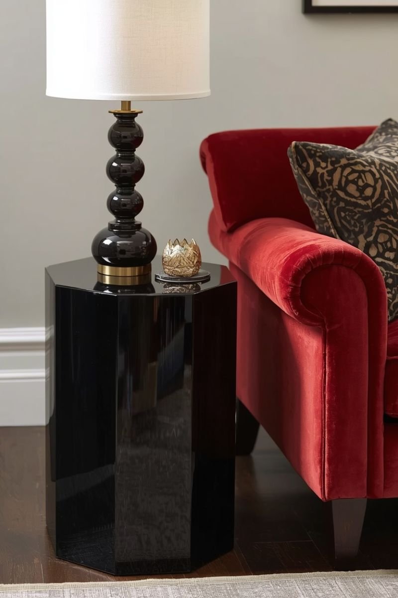 Lacquered black side table beside a velvet sofa reflecting lamp light in a Neo Deco room