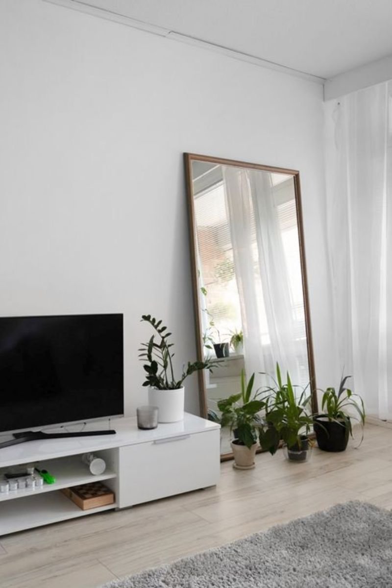 Large mirror reflecting natural light in a breezy summer living room