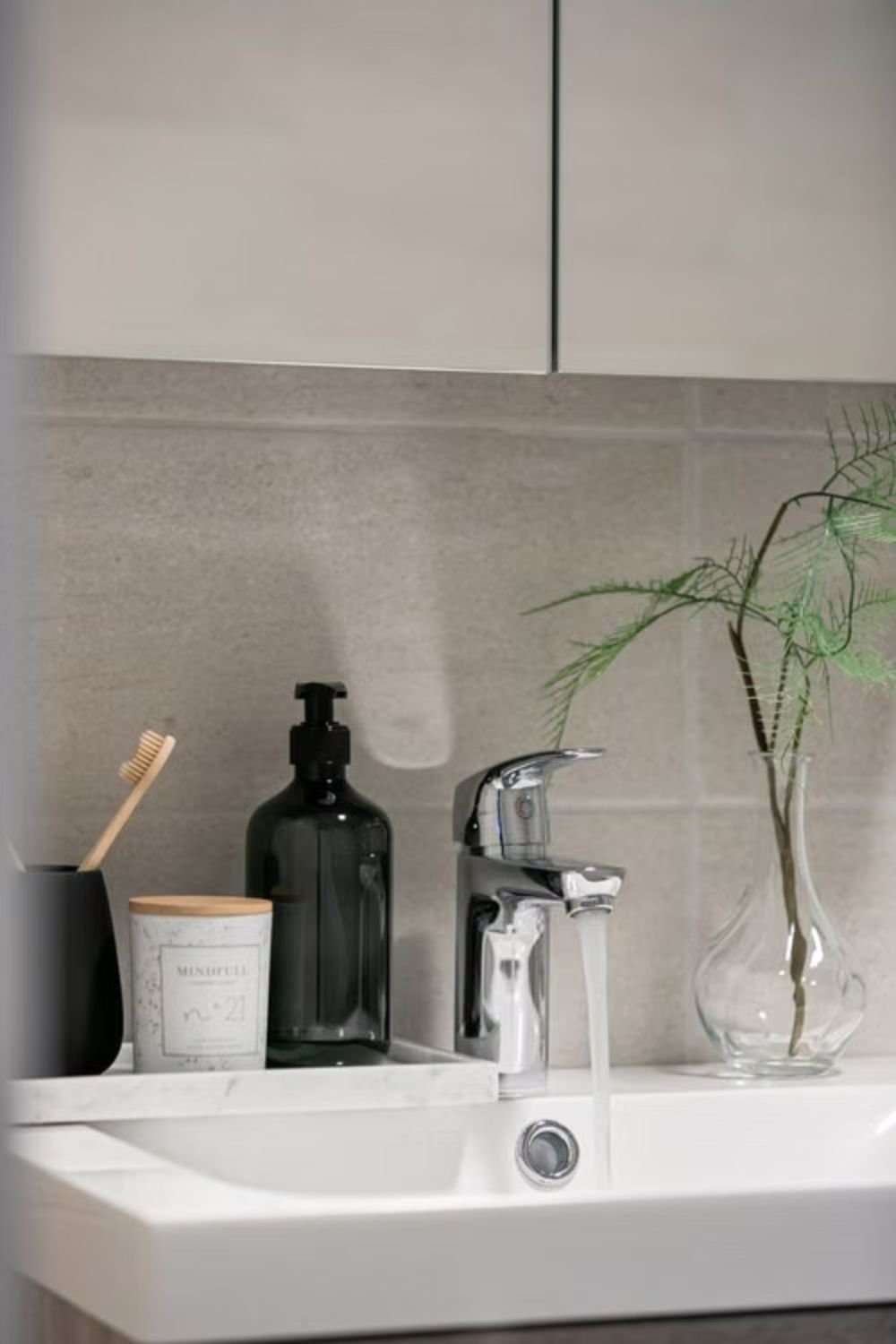 Matching ceramic bathroom accessories including soap dispenser and toothbrush holder