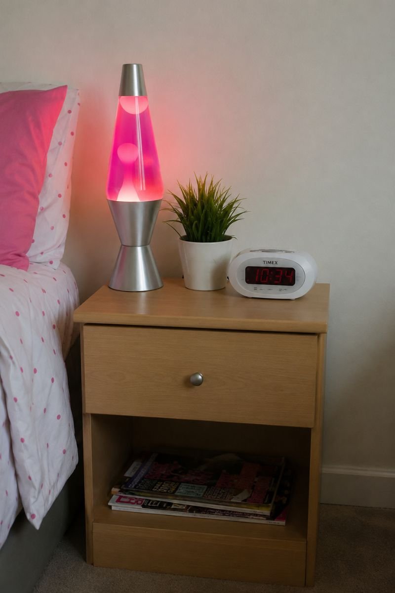 Pink lava lamp on white nightstand in Y2K bedroom