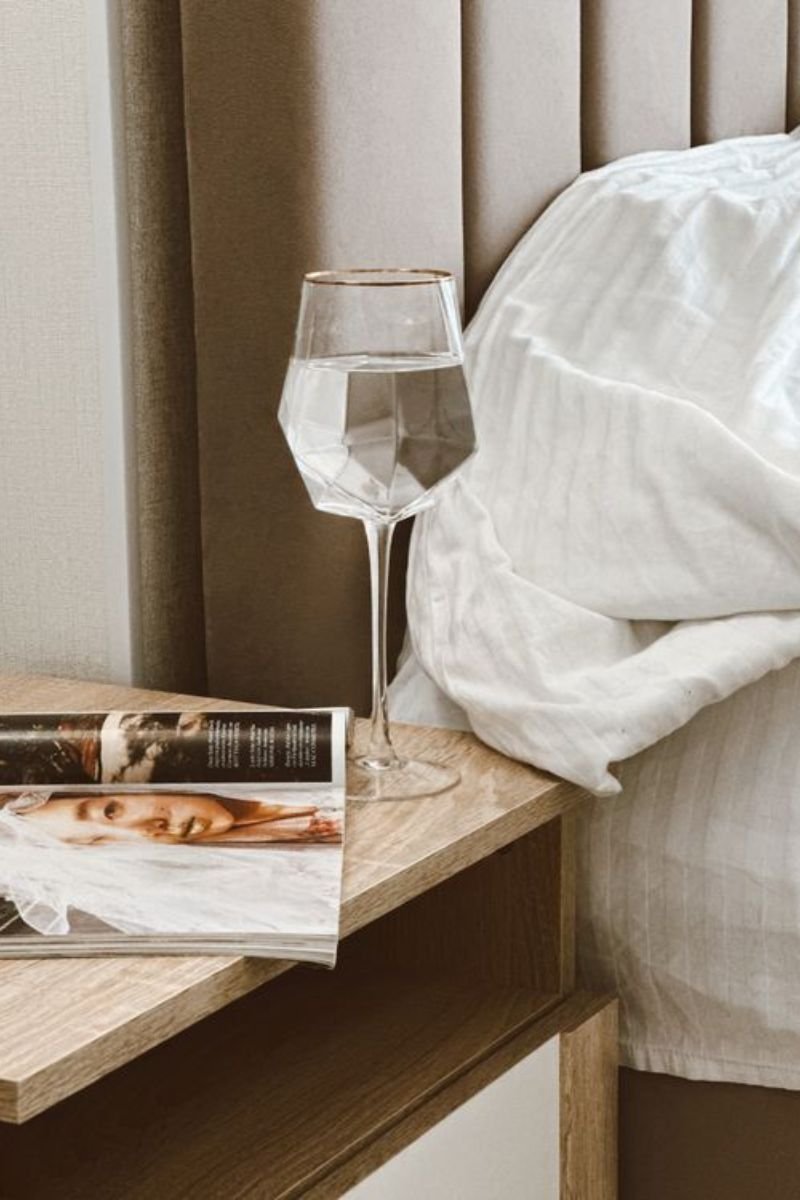 Styled nightstand with marble tray candle and book in a luxury hotel bedroom