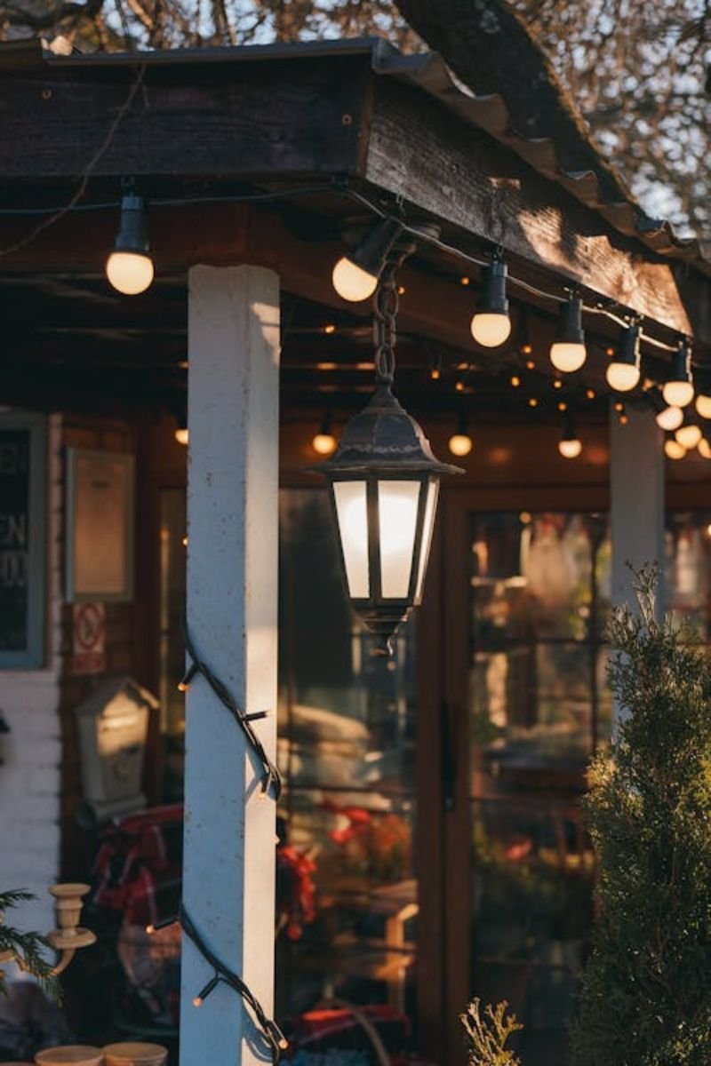 Warm string lights fall porch ceiling railing evening outdoor decor