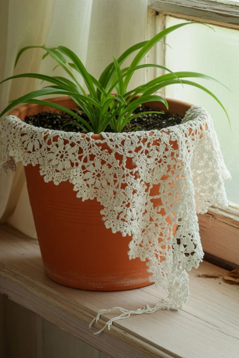 White doily draped over a terracotta plant pot on a wooden shelf