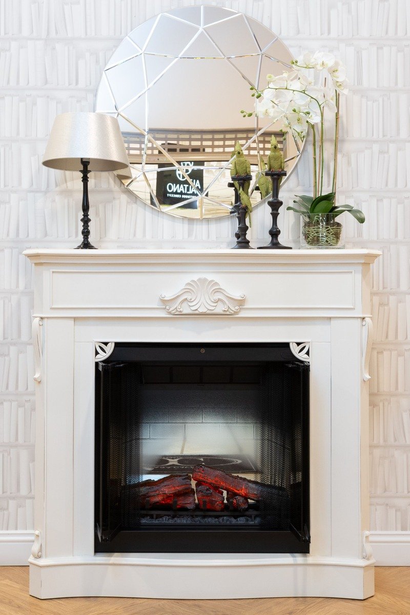 Large round mirror above a fireplace mantel