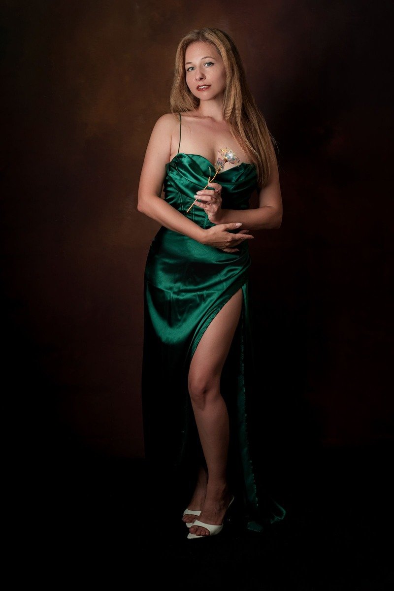 Woman in an emerald green satin dress outfit