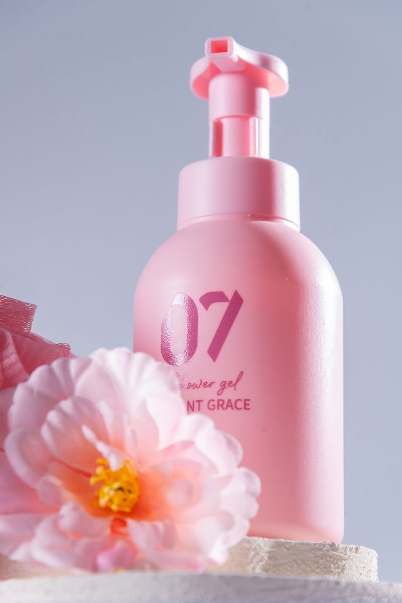 Turmeric body wash bottle with turmeric root and powder in background