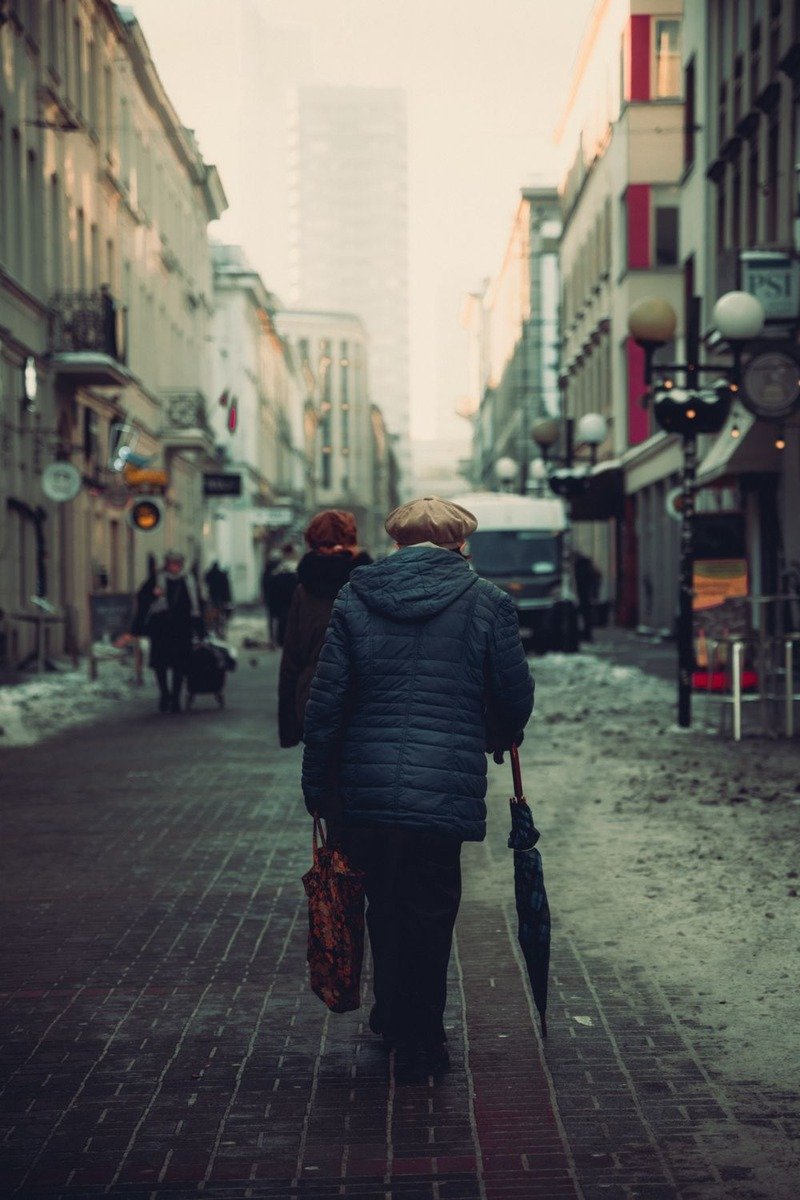 Woman over 50 in a navy puffer coat on a snowy street