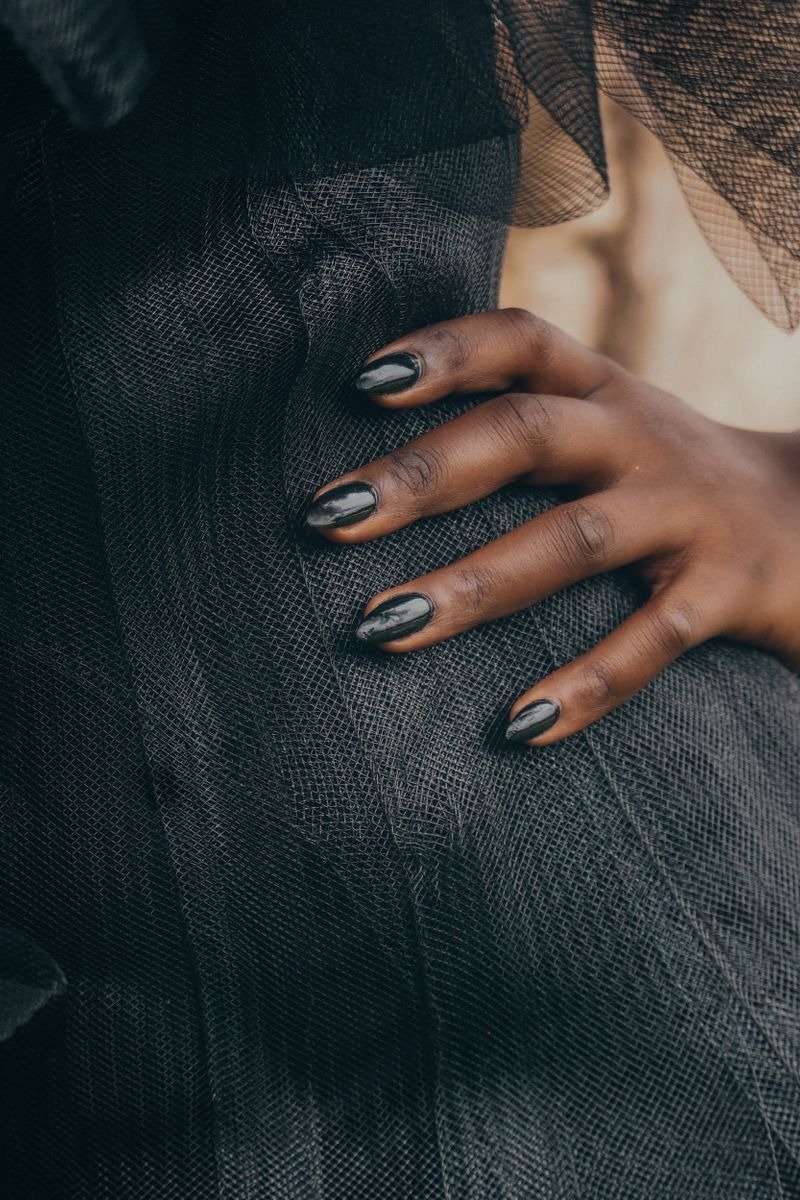 Black nail polish with fine holographic sparkle on short nails