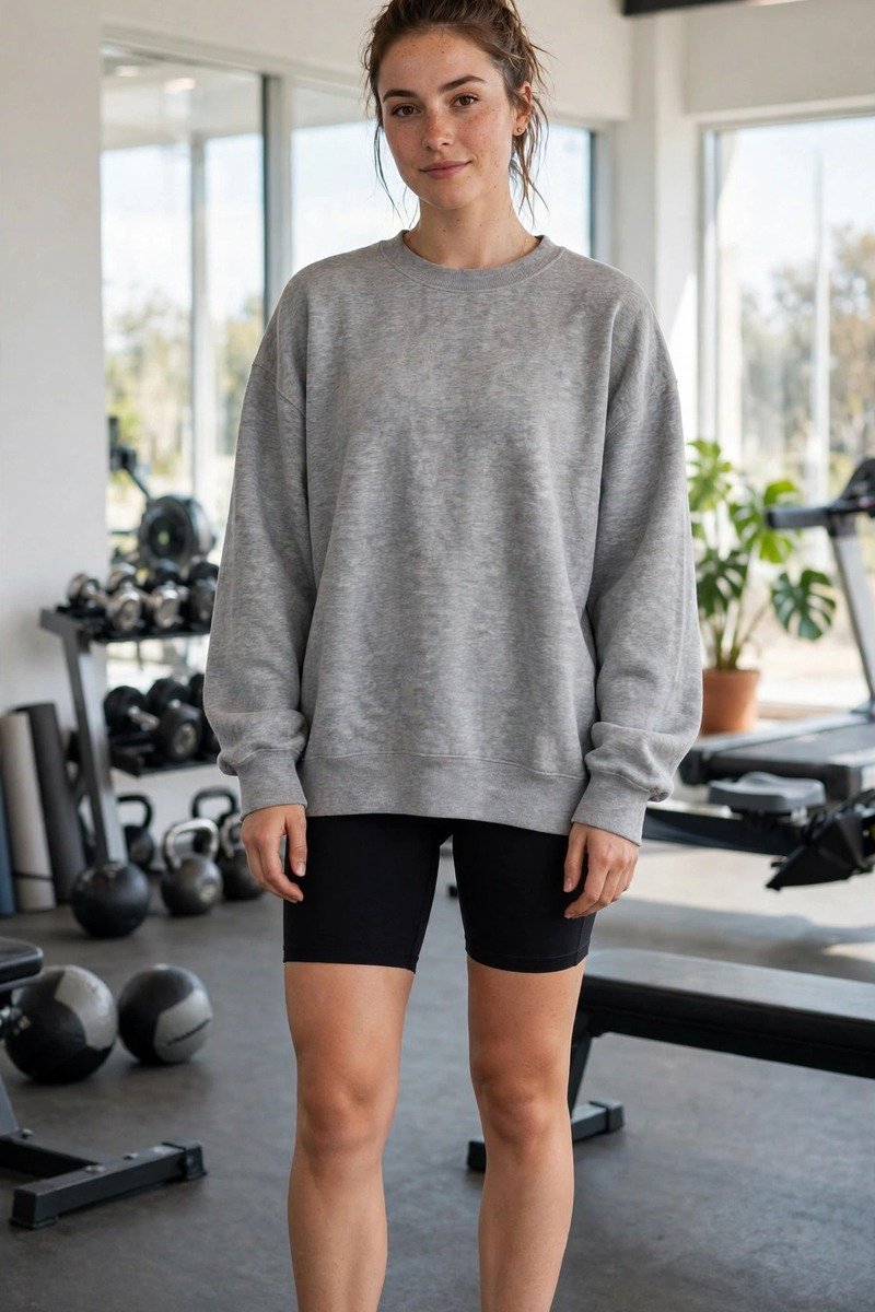 Woman in biker shorts and oversized sweatshirt at the gym