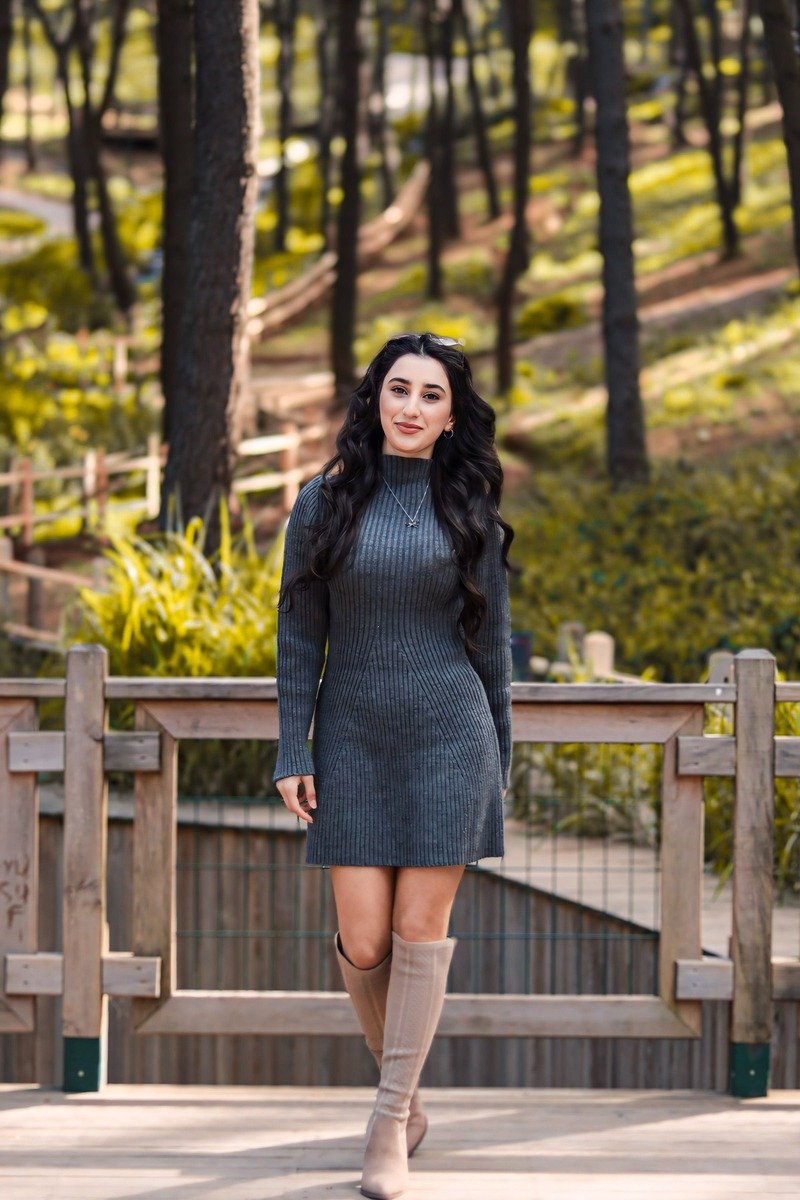Woman over 40 in a knit sweater dress with knee high boots