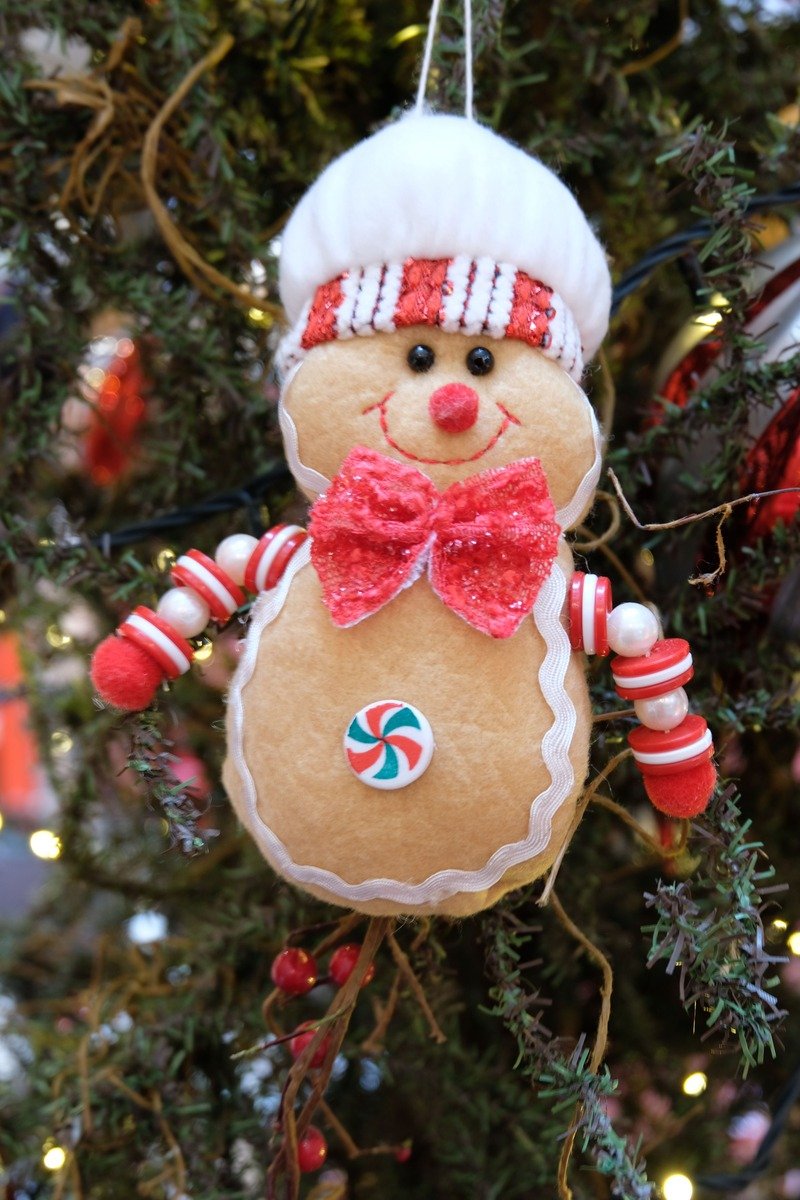 Plush gingerbread Christmas ornament hanging on a tree