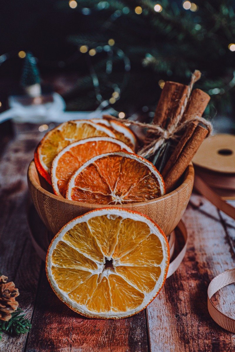 Dried orange slices and cinnamon sticks in a bowl
