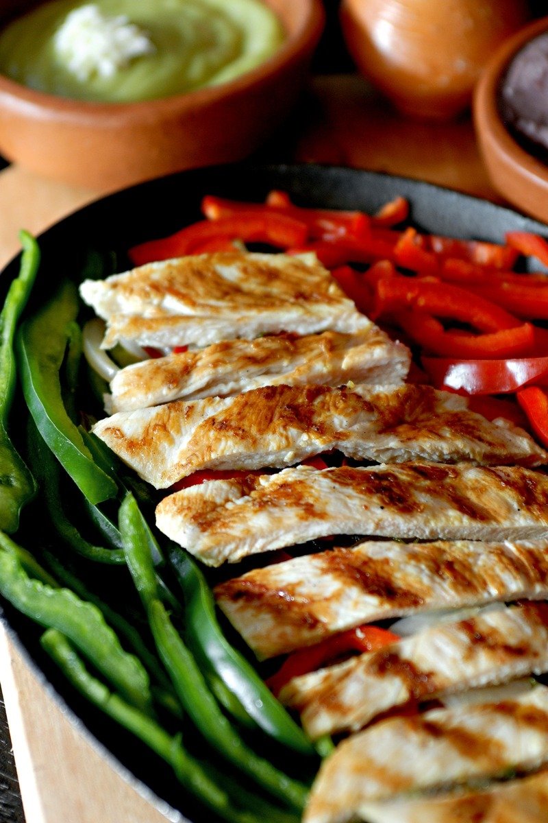 Chicken fajitas in a skillet with peppers