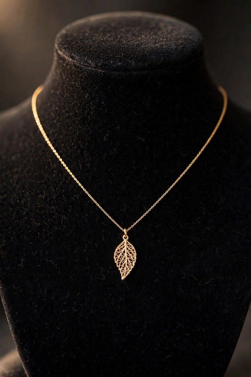 Delicate gold pendant necklace on a bust