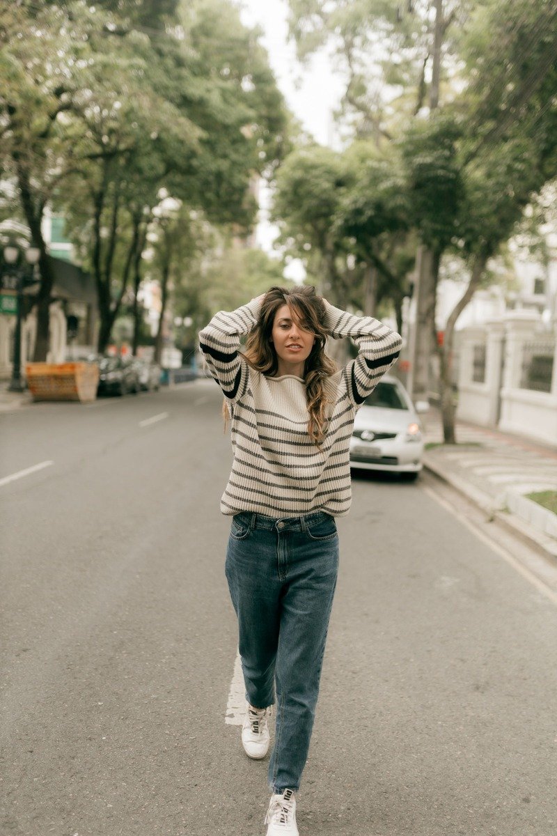 Woman in an oversized sweater with boyfriend jeans and a half tuck