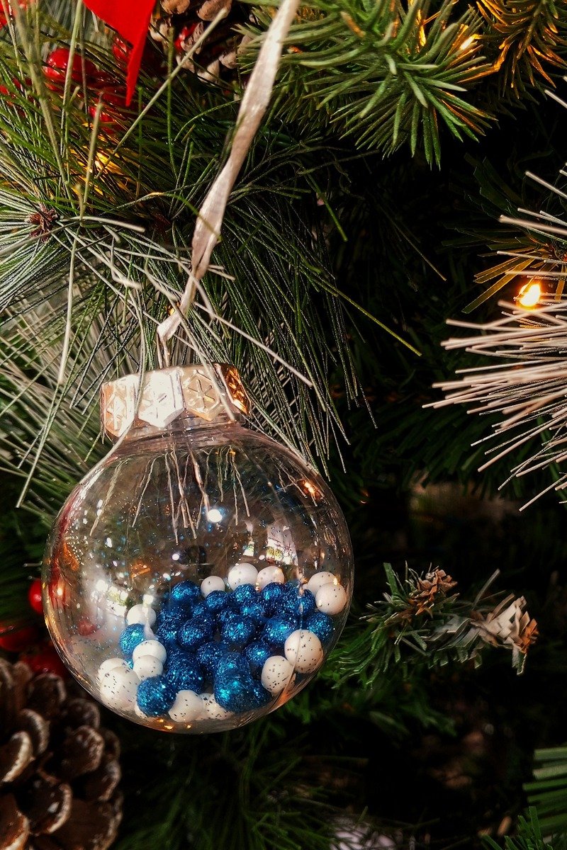 Clear bauble ornament filled with blue and white beads
