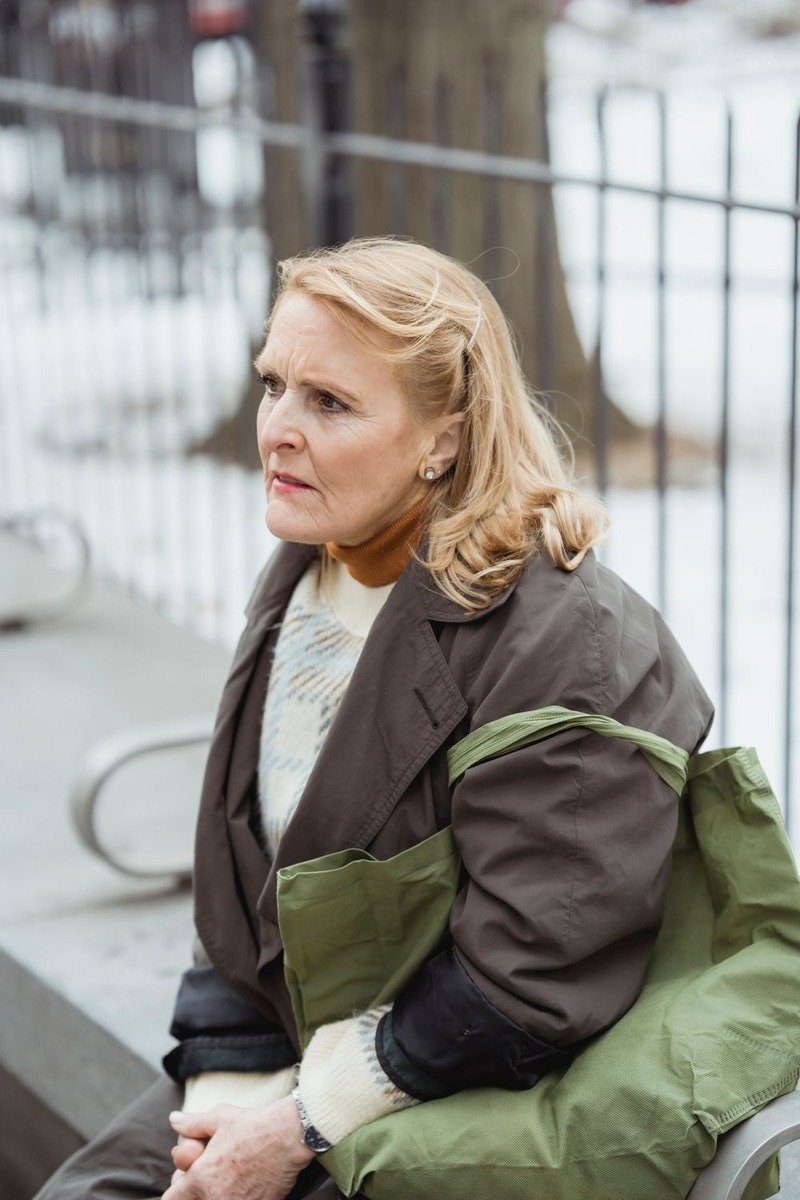 Woman over 50 in a brown winter coat in the snow