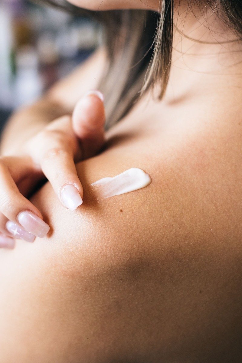 Nighttime retinol body lotion beside a bedside lamp glow