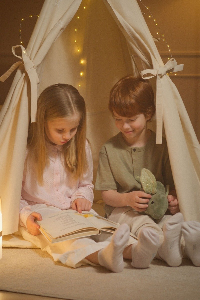Whimsical blanket fort lounge with fairy lights and piles of pillows for reading
