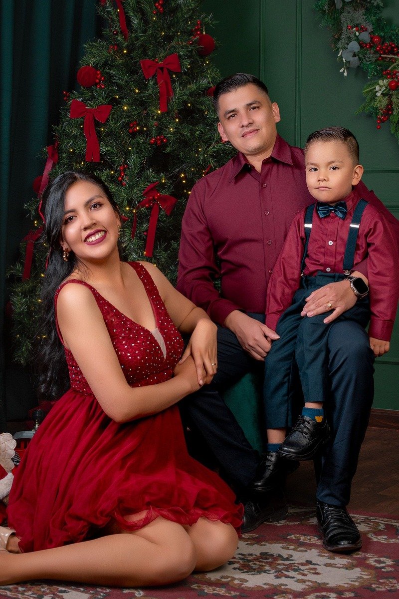 Family in formal green and gold outfits for a Christmas portrait