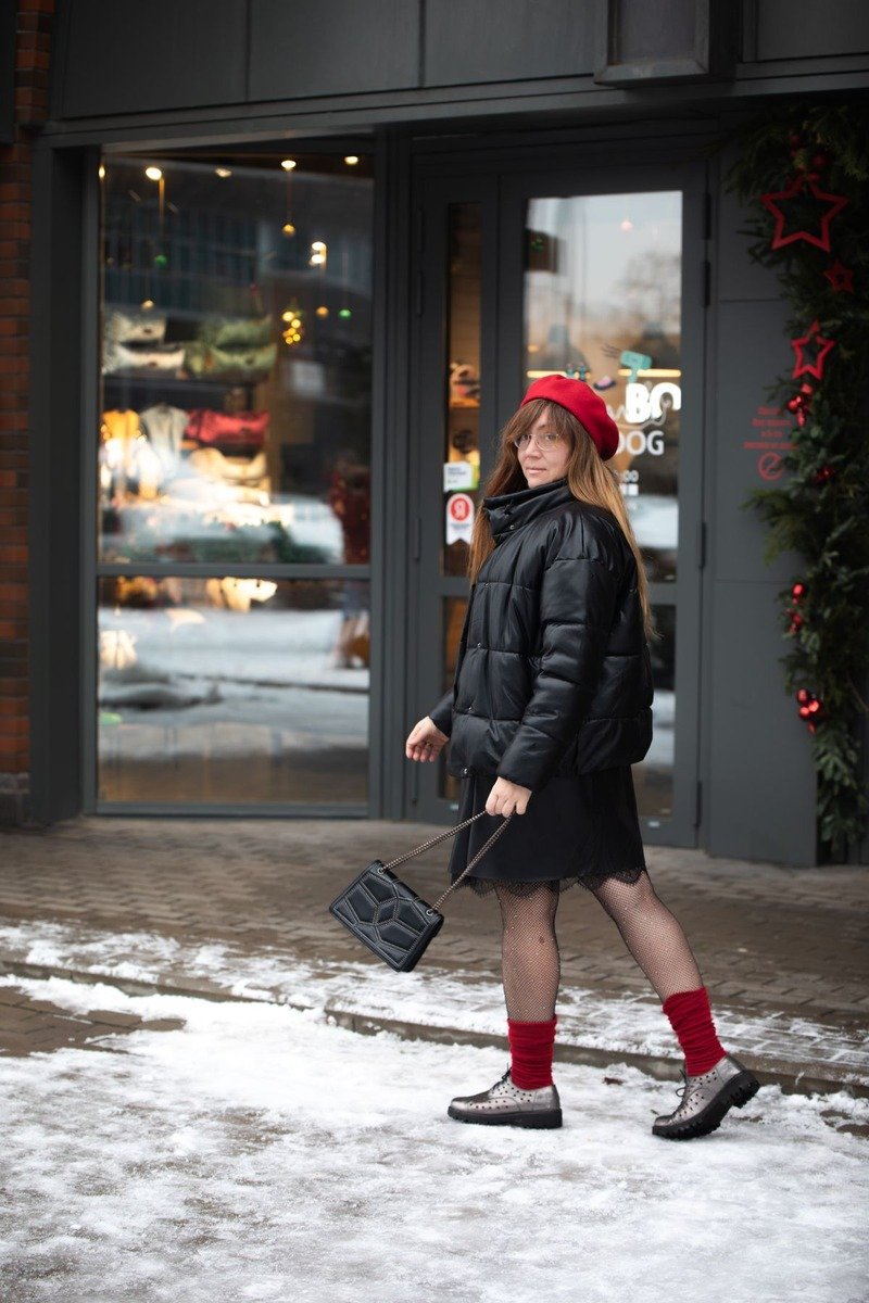 Woman in a puffer jacket over a knit dress in the snow