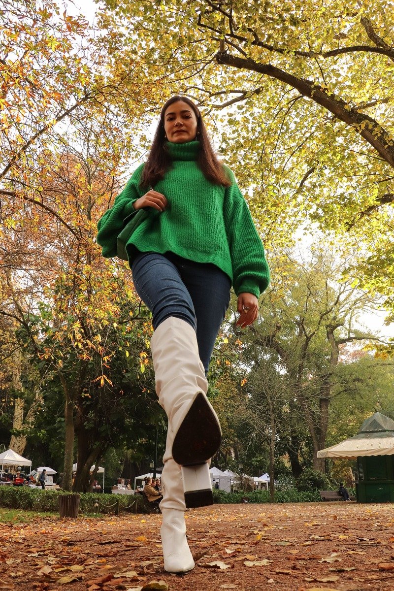 Woman in a green sweater with white boots