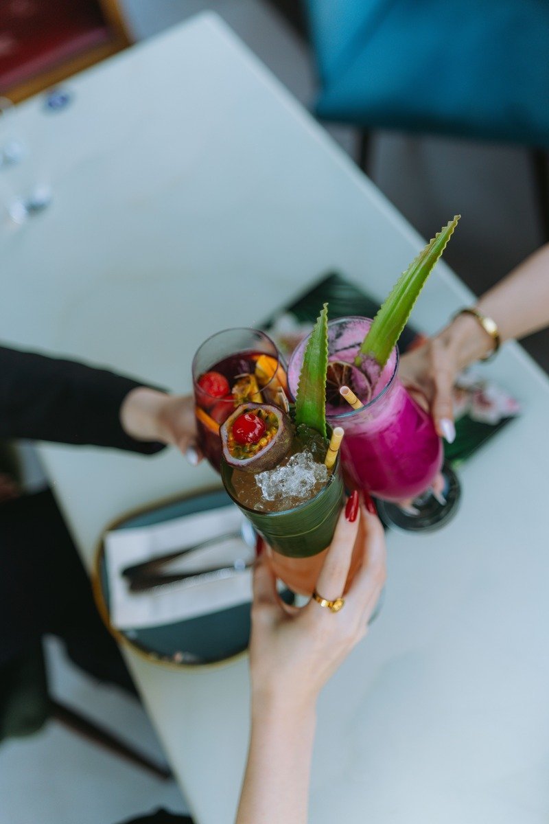 Literary cocktail hour with book-inspired drinks on a bar cart beside stacked novels