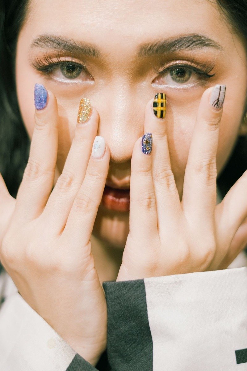 Mismatched skittle nail art with glitter, plaid and heart designs