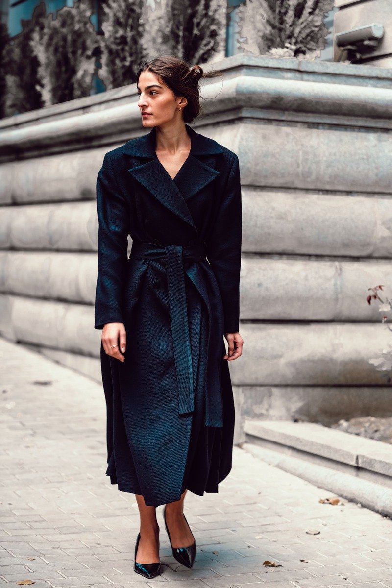 Woman in a belted wrap coat over a midi dress in winter
