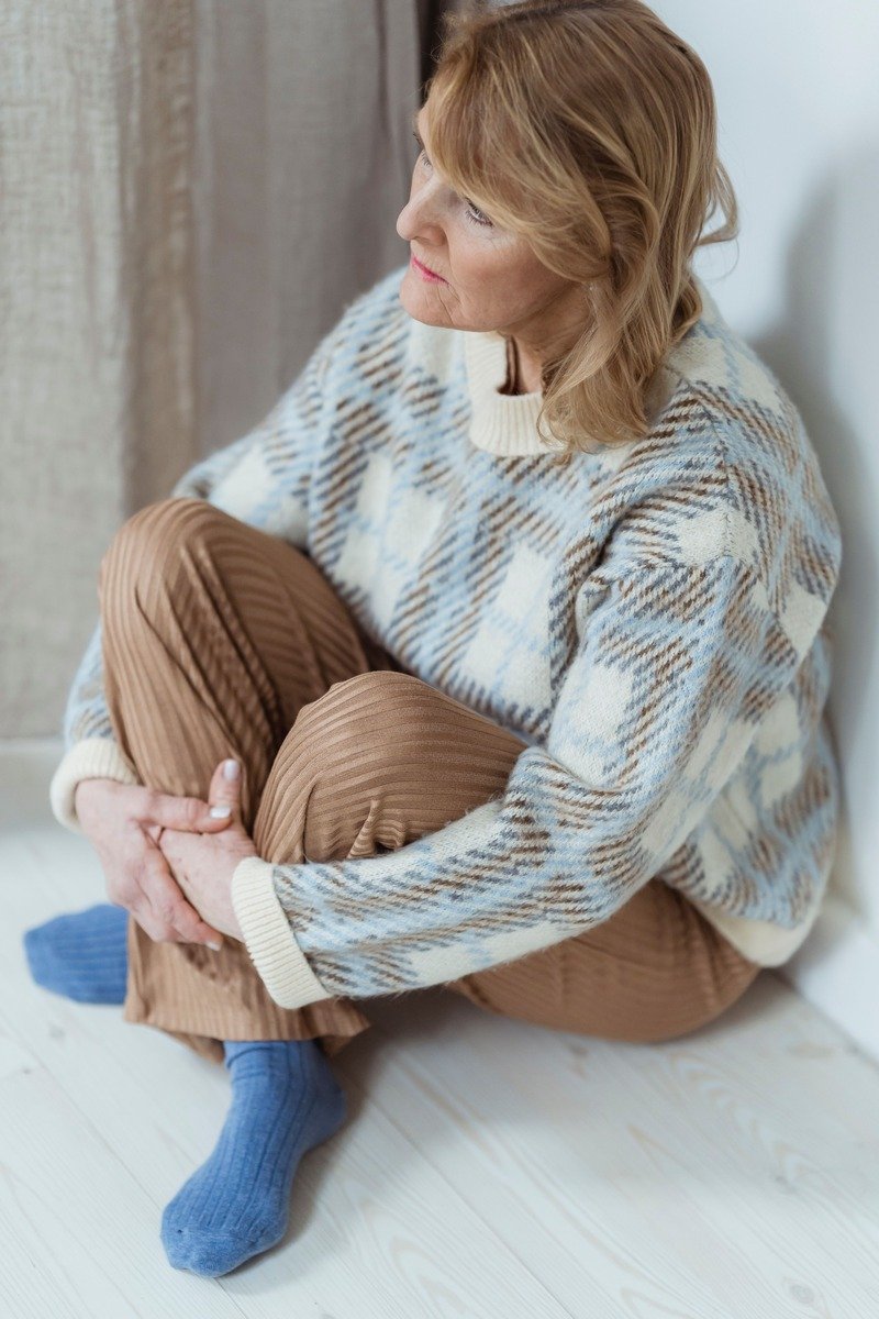 Woman over 40 in a chunky sweater with corduroy pants and boots