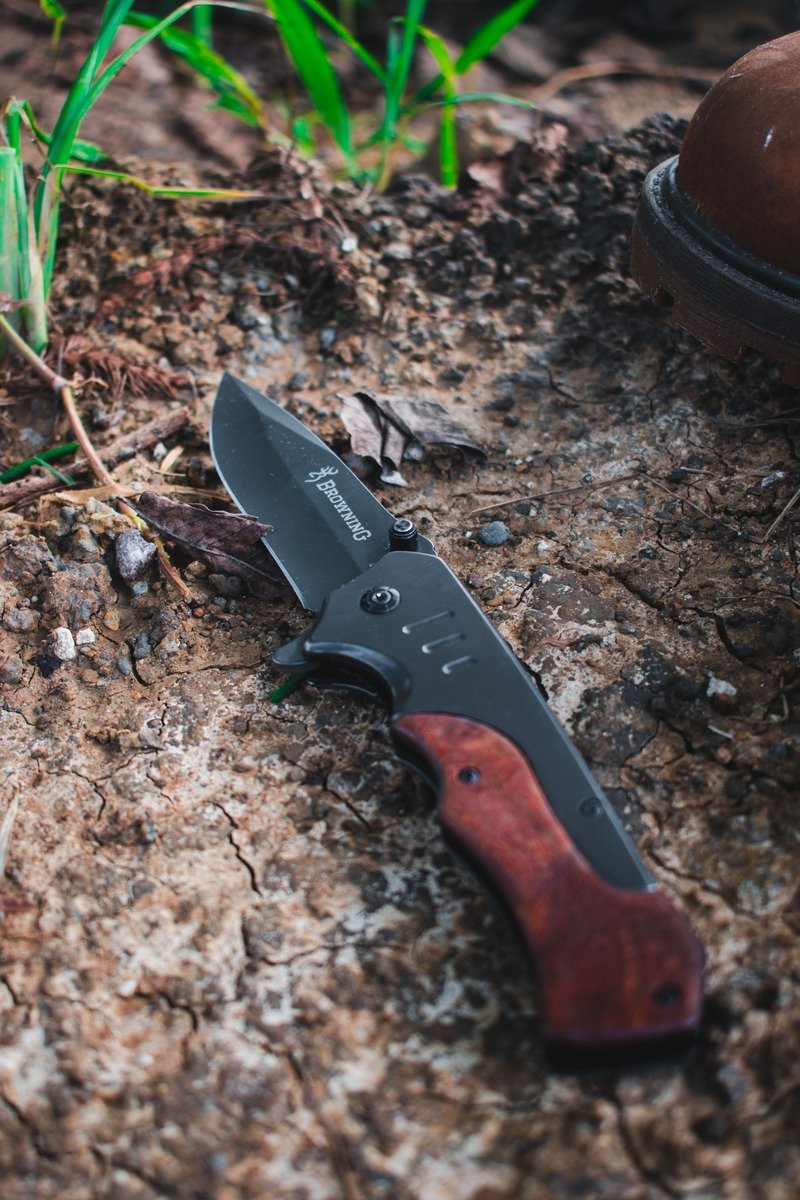 Folding pocket knife with a wooden handle outdoors