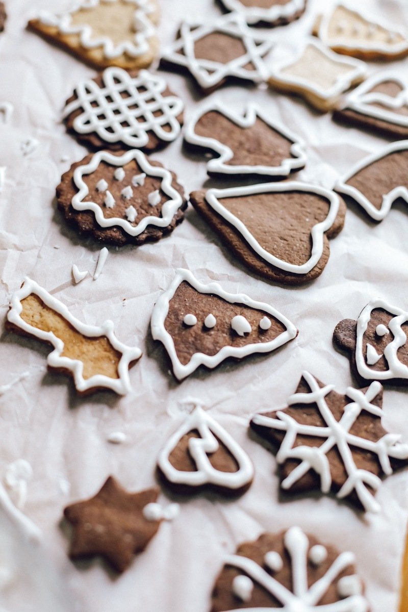 Homemade iced gingerbread cookies in Christmas shapes on baking paper
