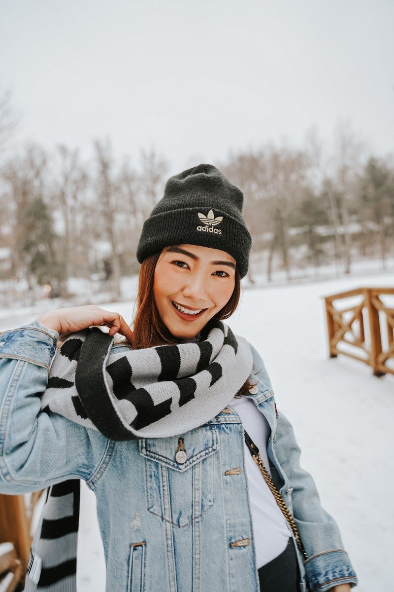 Woman over 40 in a denim shirt and jeans with a wool scarf