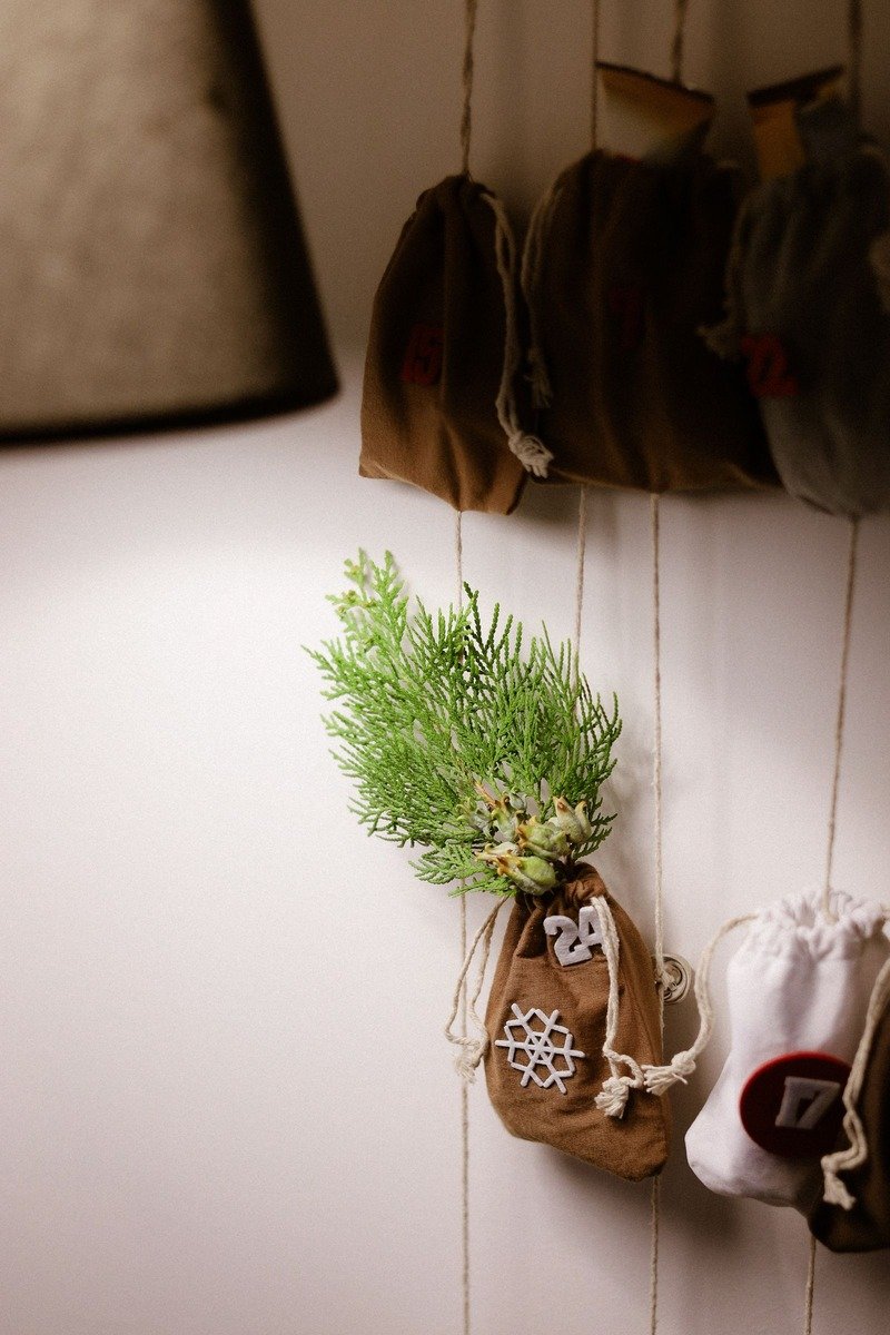 Burlap pouches advent calendar hanging on wall hooks