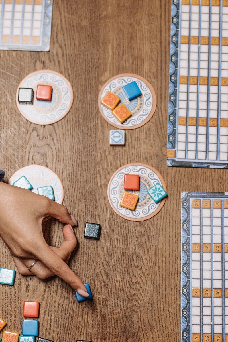 Hands playing a board game at a table