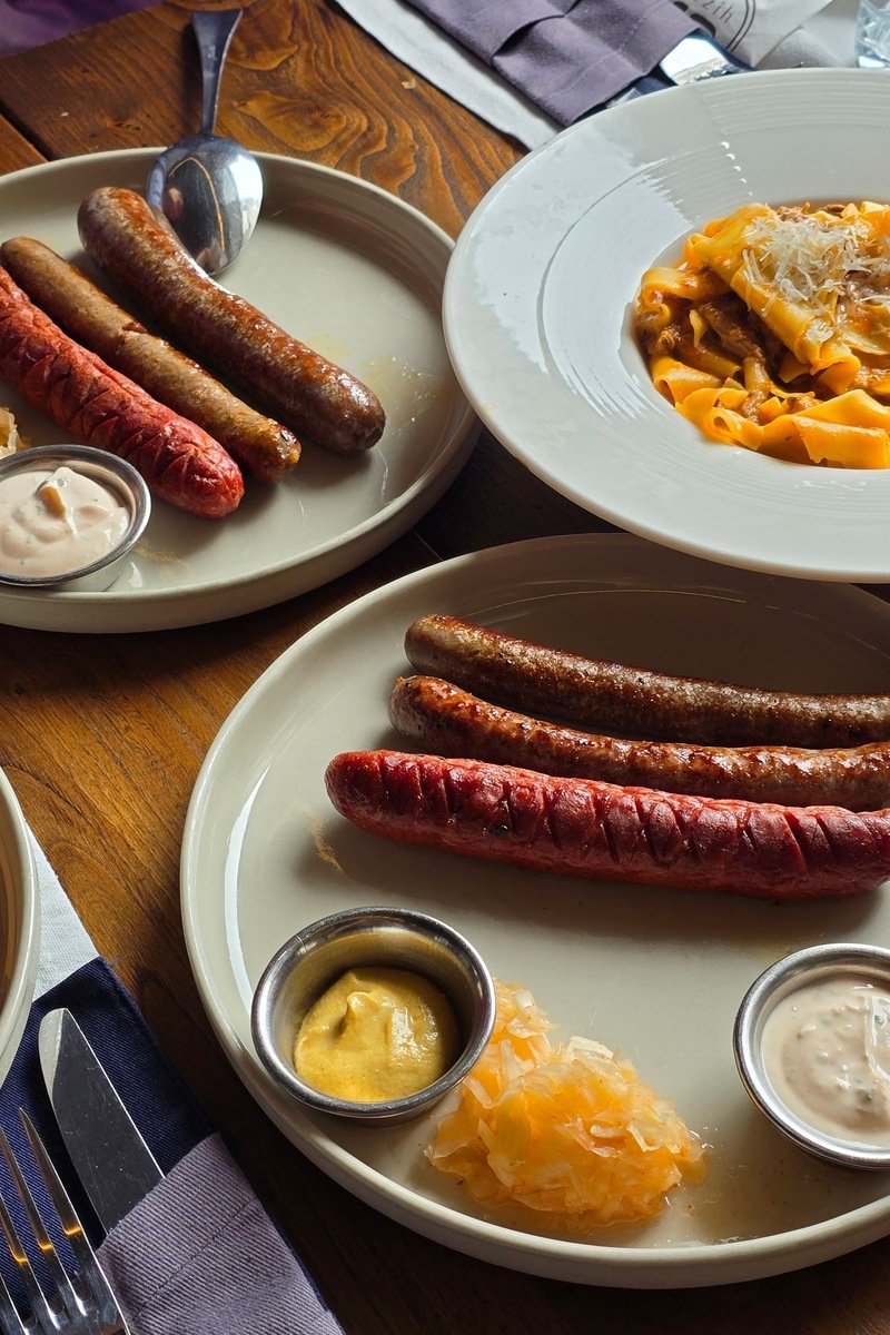 Grilled German sausages served with sauerkraut and mustard on a restaurant table