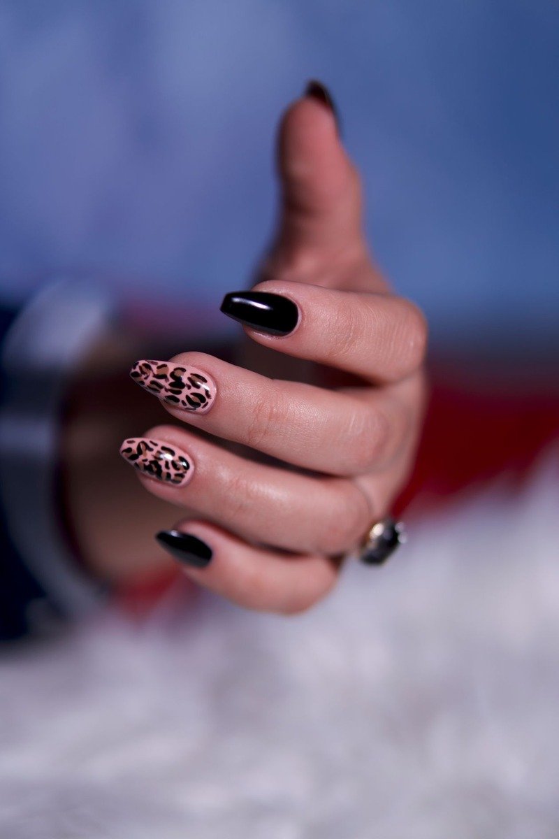 Leopard print accent nails on a warm nude base