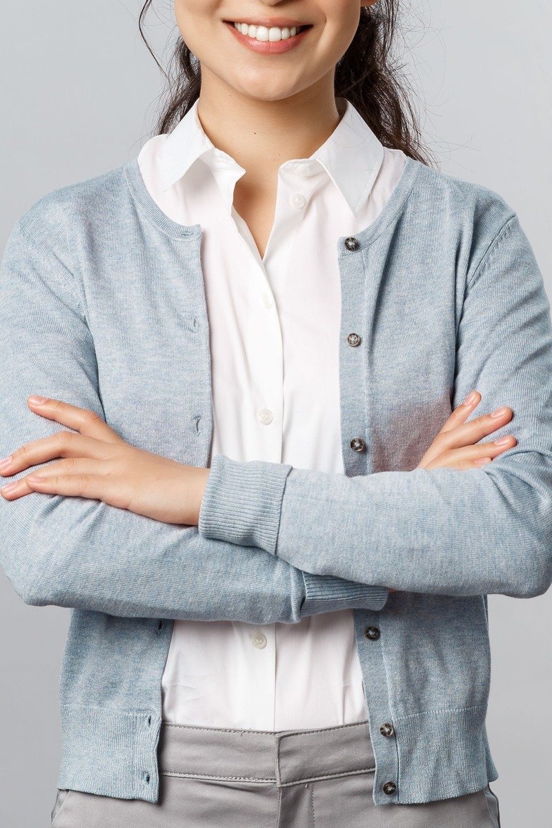 Woman wearing a cardigan over a button-down shirt at work