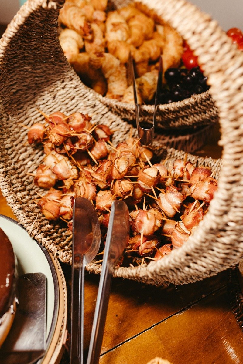 Bacon wrapped dates spilling from a woven basket