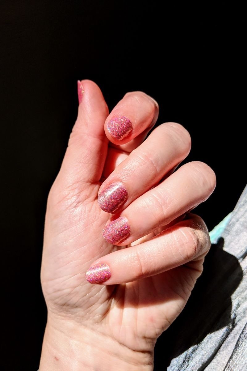 Silver holographic chrome nails reflecting rainbow light