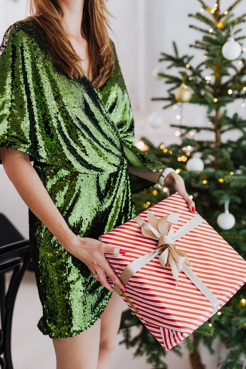Woman in an emerald wrap dress at a winter celebration
